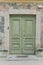 A half open wooden door of the church against the backdrop of a stone wall. Wooden doors of the church