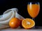 Half oranges are placed on a sack on the table, with a glass of orange juice on the side on a black background, still life