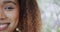 Half portrait of happy biracial woman with curly hair smiling at home, copy space, slow motion