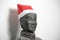 Half profile of Chinese terracotta warrior stature wearing santa hat