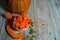 Half a pumpkin, slices, bowl of chunks, seeds on a light blue wooden background.