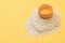 Half a raw egg on a pile of flour on a yellow background