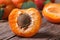 Half ripe apricot closeup on wooden table, horizontal