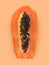 Half of ripe papaya fruit with seeds on a color background. Appetizing tropical fruit