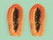 Half of ripe papaya fruit with seeds on a color background. Appetizing tropical fruit