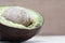 Half rotten avocado on wood background