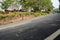 Half-shaded hillside blacktop driveway on sunny day