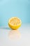 Half of squezzed lemon on white table. Minimalistic image of yellow citrus on bright studio background