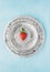 Half strawberry on silver platter , blue background, top view