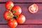 Half of a tomato with cluster over dark table