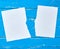 Half torn blank white sheet on a blue wooden background