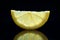 Half a transparent lemon wedges on a black background.