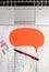 Half view trendy open laptop blank speech bubble facing downwards pen colored clips lying vintage wooden table. Personal