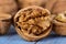Half walnut kernel and whole walnuts on a wooden background