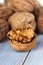 Half walnut kernel and whole walnuts on a wooden background