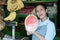 A half watermelon in the hand of a woman fruits seller