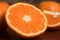 Half and whole fresh oranges on wooden table