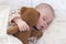 Half-year baby kid sleeps with a teddy bear. Portrait of cute sleeping baby, plump lips, snub nose. close-up soft focus