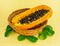 Half yellow fruit ripe papaya with black round grains in a wicker basket