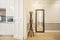 Hall with coat rack and mirror and entrance to the kitchen in a vacation rental apartment