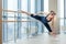 In the hall girl doing stretching near Barre