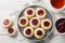 Hallongrottor Swedish Thumbprint Cookies closeup on the plate on the wooden table. Horizontal top view