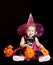 Halloween baby witch with a carved pumpkin