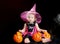 Halloween baby witch with a carved pumpkin