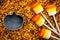 Halloween background - candy corn marshmallow pops on colored sugar sprinkling and cutter pumpkin