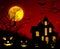 Halloween background. A creepy castle with glowing windows and pumpkin faces. Silhouette of a house, trees and bats with a glowing