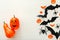 Halloween background with jack-o`-lanter, pumpkins, paper bats, spiders, confetti on white wooden background. Halloween holiday