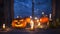 Halloween background, pumpkins and Jack-o ` - lantern next to burning candles on the background of an ominous night