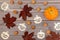 Halloween background of ripe little pumpkin, fallen maple leaves and stenciled Halloween symbols