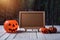 Halloween background. Spooky pumpkin, chalkboard on wooden floor