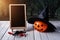 Halloween background. Spooky pumpkin, chalkboard on wooden floor