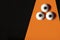 Halloween background, three-eyed orange monster on a black