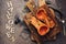 Halloween, baked pumpkin and spider, dark rustic background. Top view, flat lay