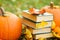 Halloween Books.Study and education concept. stack of books,maple leaves and pumpkins in autumn garden.Autumn reading