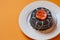 Halloween cake in a white plate. Surface orange background.