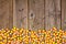 Halloween candy corn bottom border on a rustic wood background