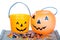 Halloween candy and pumpkin bucket on wood