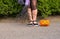 Halloween closeup witch legs in boots and with broomstick and pumpkin.