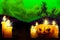 Halloween colorful haunting dark texture - set of candles on left and candle in pumpkin style on right, glowing candles concept -