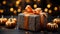 Halloween composition in dark tones. Elegant gift box with bow, guilded pumpkins. Blurred background with bokeh effect