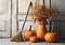 Halloween composition with pumpkins,dried tree branches, autumnal leaves and broom