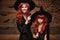 Halloween Concept - Beautiful caucasian mother dress up for her daughter in witch costumes and long curly hair ready for celebrati