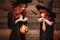 Halloween Concept - Beautiful caucasian mother and her daughter with long red hair in witch costumes with Halloween candy and magi