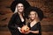 Halloween Concept - beautiful caucasian mother and her daughter in witch costumes celebrating Halloween with sharing Halloween can
