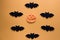 Halloween concept. Black paper bats on orange background. Top view.Halloween pumpkins and bats on orange background. Top view.