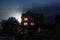 halloween concept. blurred defocused night time scene with hounted house and garden. foggy night, glowing windows and